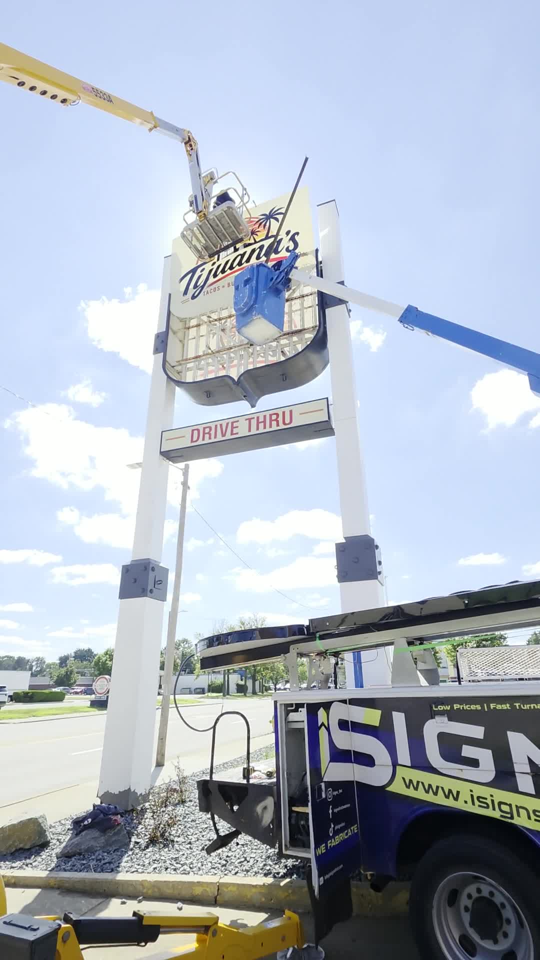 Crew installing a freestanding sign using lifts